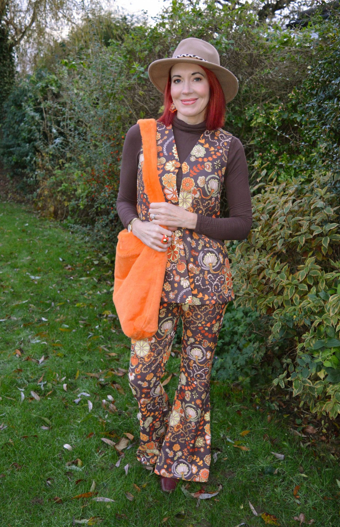The Hippie Shake Harlow brown floral waistcoat and flares, Fenella Smith London Clemmie Orange Faux Fur Bag, Zara camel fedora